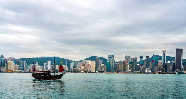 Barco de lixo tradicional chinês na frente do horizonte de Hong Kong — Fotografia de Stock