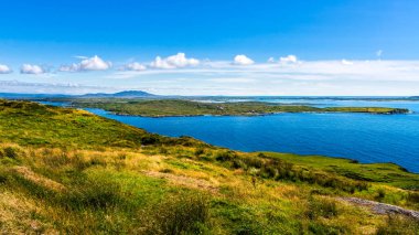 Küçük köy, yeşil alanlar ve sahildeki çayırlar, Wiled Atlantic Way, İrlanda