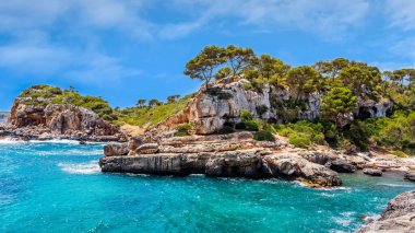 Sahilde ve koyda kayalıklar ve turkuaz deniz suyu, Cala Salmunia, Mallorca, İspanya