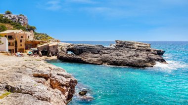 Turkuaz deniz suyuyla sahil ve körfez, Cala Salmunia 'daki ev köyü, Mallorca, İspanya