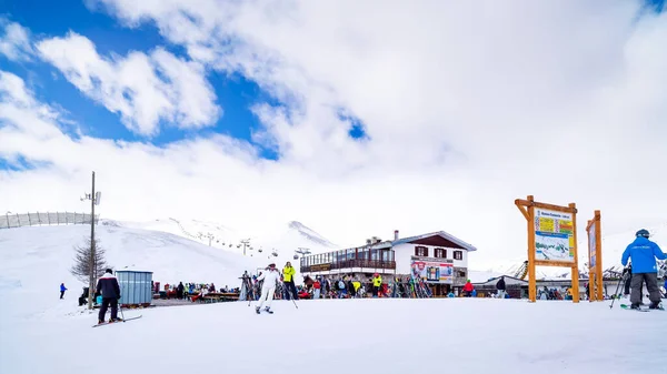 Esquiadores, snowboarders relajarse cerca de la cabaña de montaña, Alpes, Livigno, Italia — Foto de Stock