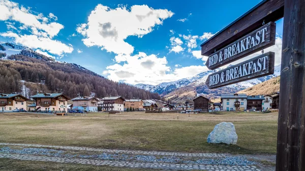 Bed and Breakfast bord wijzend naar Livigno dorp, oude houten huizen, Italië, Alpen — Stockfoto