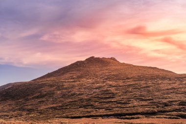 Dramatic sunset, setting sun highlighting Slievebeg Mountain peak in Mourne Mountains, County Down, Northern Ireland clipart