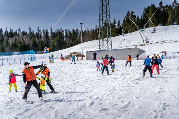 Gruppen von Skifahrern, Kindern und Erwachsenen lernen das Skifahren mit Skilehrern — Stockfoto