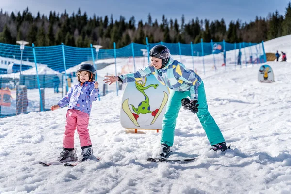 波兰鞑靼 Bialka Tatrzanska 年轻快乐的滑雪者女孩和她的妈妈在绿色滑雪区学习滑雪 — 图库照片