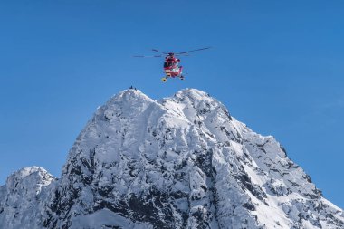 Kurtarma helikopteri dağcıları kurtardı. Kışın Swinica 'nın dik ve kayalık zirvesindeki insanlar, Tatra Dağları, Polonya