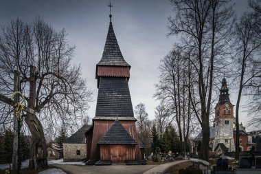 Bialka Tatrzanska 'daki eşsiz 17. yüzyıl ahşap kilisesi. Karanlık, kasvetli fırtına bulutları ve dramatik gökyüzü. Tatra Dağları, Polonya