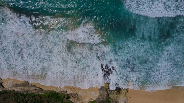 Aerial view to ocean waves. Top view of beautiful beach. Aerial drone shot of ocean water at the beach