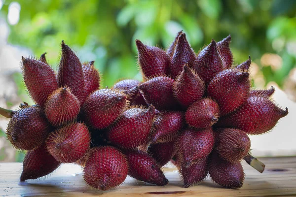 Fresh ripe salak fruit or snake fruits on the wooden table. Salacca zalacca - exotic thai fruit.