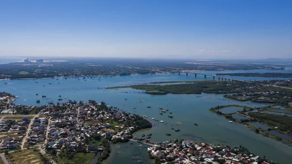 Hoi An river estuary top view with the boats on water, river bridge and local Vietnamese villages panoramic view