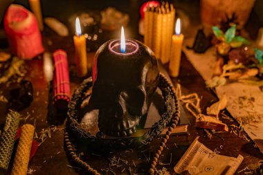 Tablo hala LIF tütsü sopa, ahşap tespih, balmumu mum, otlar ve küçük sihirli şeyler ile siyah kafatası mum yanan