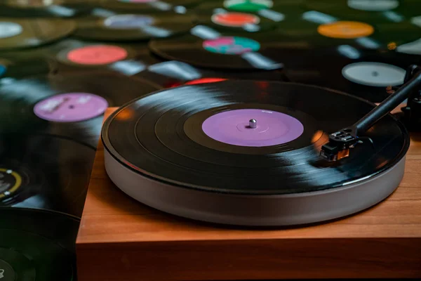 ビニールレコードの背景のコレクション上のターンテーブル上のビニールレコード — ストック写真