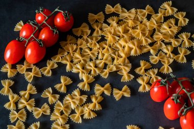 Mutfak masasında domates ile haşlanmış kelebek makarna, yemek pişirme konsepti 
