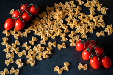 Mutfak masasında domates ile haşlanmış kelebek makarna, yemek pişirme konsepti 