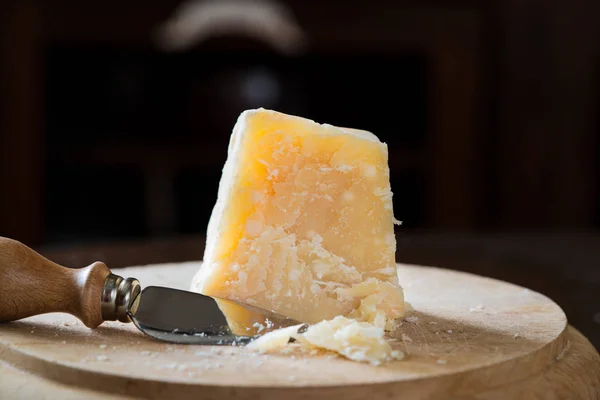 木板和刀上的一块帕米吉亚诺奶酪 图库图片