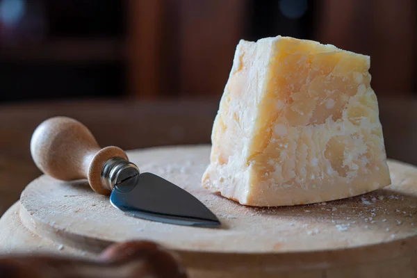木板和刀上的一块帕米吉亚诺奶酪 免版税图库图片