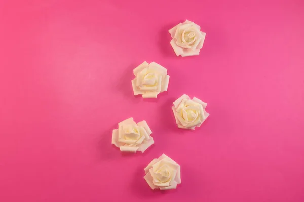 Pattern white white roses on pastel pink background. Flat lay, top view.