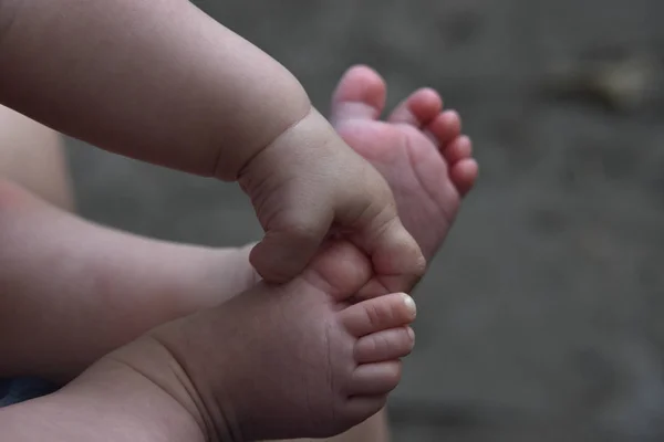 Jambes et poignées de bébé près sur fond gris — Photo