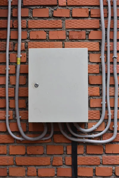 Electrical box on a brick wall. plastic cable channels — Stock Photo, Image