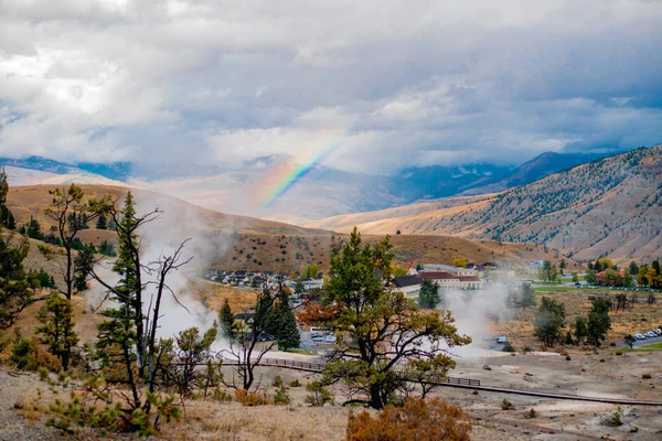 Un arcobaleno punteggia il villaggio fumoso . — Foto Stock