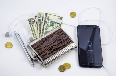 Para, bir kavanoz viski ve kulaklık ile bir cep telefonu. Erkek aksesuarlar. İş erkek beyaz bir arka plan üzerinde kümesi. Başarılı adam.