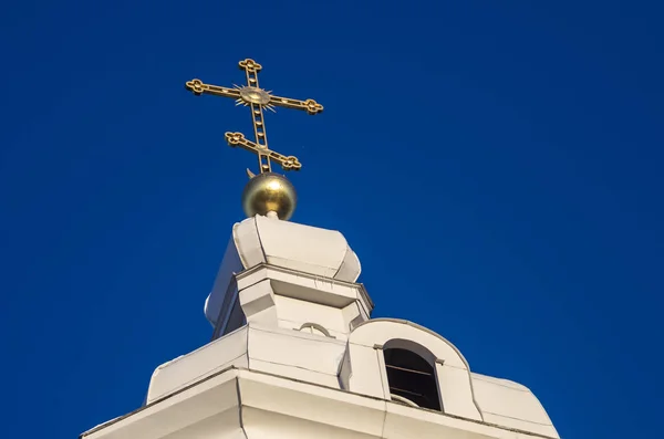 Golden orthodox cross on the dome of the church bell tower. Cross against the blue sky. Orthodox faith.