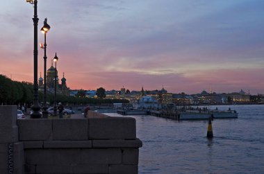 Lieutenant Schmidt Embankment in St. Petersburg on a summer evening. Sunset over the evening European city near the water. North Venice. St. Petersburg, Russia, Vasilyevsky Island, May 25, 2018 clipart