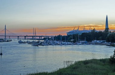 Yaz günbatımı Neva üzerinde gece beyaz. Köprü, tekneler ile iskele, stadyum ve yeşil eğlence parkı şehir panoraması. Turkuaz - pembe açık gökyüzü. St Petersburg, Rusya, 27 Haziran 2018