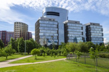 Modern mimarinin iş merkezinin cam kuleleri. Fütüristik Finans Merkezi bina ve bir yeşil çim bir park. Saint-Petersburg Plaza, Rusya, St. Petersburg, 5 Temmuz 2018