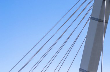 Askılı köprü mavi gökyüzüne karşı yakın çekim. Mavi bir arka plan üzerinde beyaz köprü yapısı. Tarafsız minimalist arka plan.