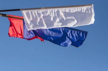 Bayraklar şunlardır: mavi, beyaz ve kırmızı. Üç renkli mavi gökyüzü. Güçlü bir rüzgar Bayraklarda. Ulusal bayram, dekorasyon şehrin.