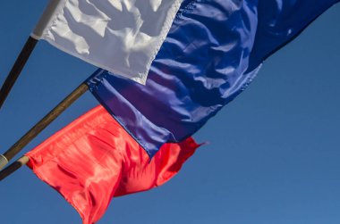 Bayraklar şunlardır: mavi, beyaz ve kırmızı. Üç renkli mavi gökyüzü. Güçlü bir rüzgar Bayraklarda. Ulusal bayram, dekorasyon şehrin.