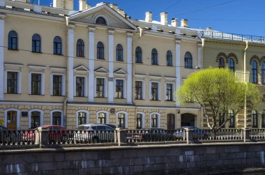 Tarihi binadaki sarı cephe klasik tarzda değil. Nehrin çeşmenin çıkabilir. Sarı bir bina karşı bir yeşil ağaç. Bahar şehirde sallayarak. St Petersburg, Rusya, 16 Mayıs 2018