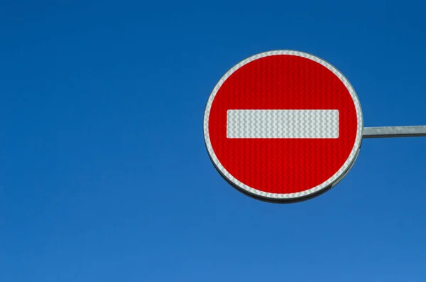 Road traffic sign STOP. Round red white sign on a blue background. The sign is not allowed. Red sign on the sky background.