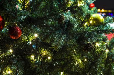 Yeni yıl ağacındaki oyuncaklar. Yakın plan. Hediyeler, toplar ve çelenklerle parıldayan bir Noel ağacı. Kartpostal için Noel ağacı yakın plan.