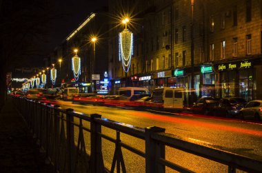 Şehrin Yeni Yıl Aydınlanması. Şehrin ışıklandırma direklerinde Noel çelenkleri. Yolun üstündeki süsler. Gece şenliği atmosferi. Moskova Meydanı, St. Petersburg, Rusya, 31 Aralık 2017