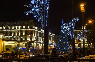 Şehrin Yeni Yıl Aydınlanması. Şehrin ışıklandırma direklerinde Noel çelenkleri. Parlak şehir yılbaşı tasarımları. Noel ağacı. Sennaya Ploshchad, St. Petersburg, Rusya, 31 Aralık 2017