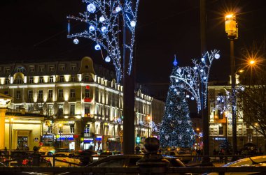 Şehrin Yeni Yıl Aydınlanması. Şehrin ışıklandırma direklerinde Noel çelenkleri. Parlak şehir yılbaşı tasarımları. Noel ağacı. Sennaya Ploshchad, St. Petersburg, Rusya, 31 Aralık 2017