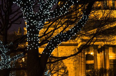Gece şehri ışığın altında. St. Isaac Katedrali 'nin önünde parlayan ışıkları olan bir Noel ağacı. Kartpostallar için arka plan. St. Petersburg, St. Isaac Meydanı 29 Aralık 2017
