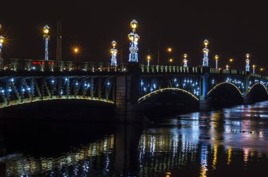 Yeni yılın Avrupa kenti ışıkların altında. Çelenklerle parıldayan Yeni Yıl Üçlemesi köprüsü. Rusya 'dan Noel kartı. St. Petersburg, Manege Meydanı, Rusya, 30 Aralık 2017