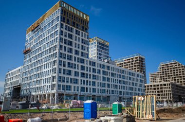 Altın Şehir konut kompleksinin inşaatı devam ediyor. Modern bina cepheleri dekorasyonu. Havalandırmalı menteşeler ve altın dekoratif unsurlar. Rusya, St. Petersburg, 9 Haziran 2020