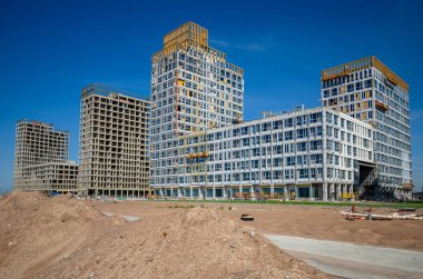 Altın Şehir konut kompleksinin inşaatı devam ediyor. Modern bina cepheleri dekorasyonu. Havalandırmalı menteşeler ve altın dekoratif unsurlar. Rusya, St. Petersburg, 9 Haziran 2020