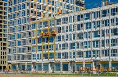 Altın Şehir konut kompleksinin inşaatı devam ediyor. Modern bina cepheleri dekorasyonu. Havalandırmalı menteşeler ve altın dekoratif unsurlar. Rusya, St. Petersburg, 9 Haziran 2020