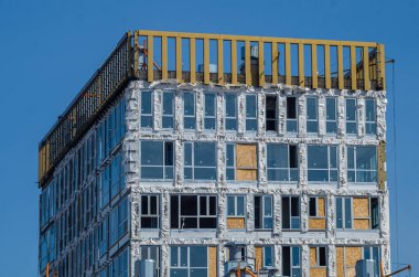 Altın Şehir konut kompleksinin inşaatı devam ediyor. Modern bina cepheleri dekorasyonu. Havalandırmalı menteşeler ve altın dekoratif unsurlar. Rusya, St. Petersburg, 9 Haziran 2020