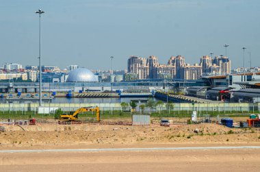 Deniz kenarında bir yerleşim tesisi inşa etmek. Morskaya setinin inşaatı devam ediyor. Suyun kenarındaki kumda evler. Rusya, St. Petersburg, 9 Haziran 2020