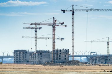 Deniz kenarında bir yerleşim tesisi inşa etmek. Morskaya setinin inşaatı devam ediyor. Suyun kenarındaki kumda evler. Rusya, St. Petersburg, 9 Haziran 2020