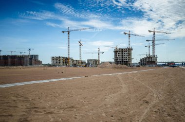 Deniz kenarında bir yerleşim tesisi inşa etmek. Morskaya setinin inşaatı devam ediyor. Suyun kenarındaki kumda evler. Rusya, St. Petersburg, 9 Haziran 2020