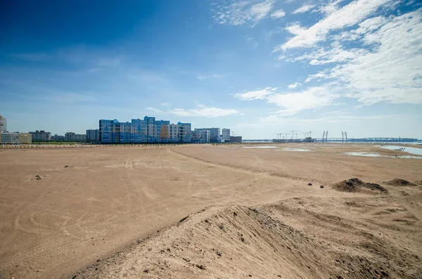 Construction of a residential complex by the sea. The progress of construction of the residential complex Morskaya embankment. Houses in the sand by the water. Russia, St. Petersburg, June 9, 2020