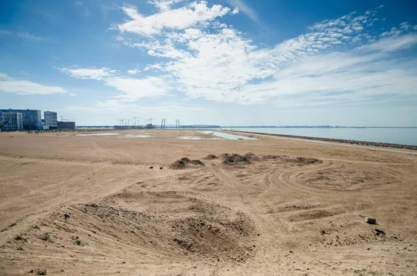 Construction of a residential complex by the sea. The progress of construction of the residential complex Morskaya embankment. Houses in the sand by the water. Russia, St. Petersburg, June 9, 2020