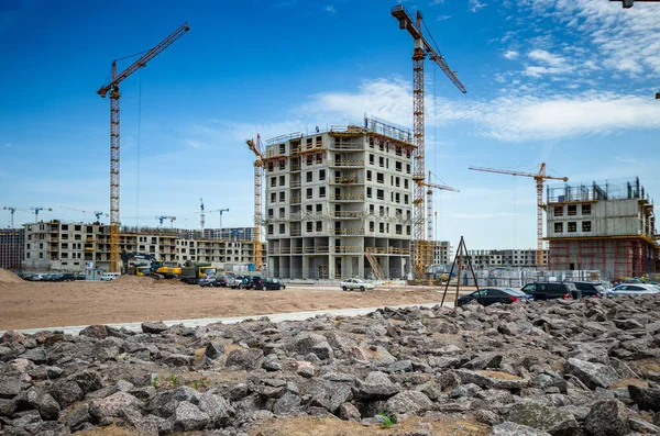 Deniz kenarında bir yerleşim tesisi inşa etmek. Morskaya setinin inşaatı devam ediyor. Suyun kenarındaki kumda evler. Rusya, St. Petersburg, 9 Haziran 2020